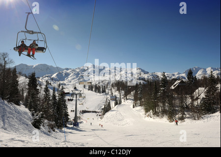 Skiers on a chair lift at the Vogel Ski Centre in the Triglav National Park of Slovenia Mount mountains Stock Photo