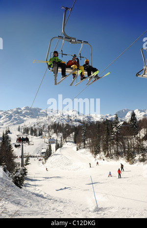 Skiers on a chair lift at the Vogel Ski Centre in the Triglav National Park of Slovenia Stock Photo