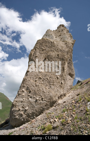 Huge rock against a blue sky with clouds in Caucasus mountains. Elbrus area. Kabardino-Balkaria. Stock Photo