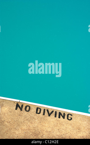 A swimming pool with a no diving sign painted on the edge of the pool. Stock Photo