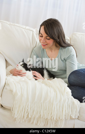USA, New Jersey, Jersey City, woman with cat on sofa Stock Photo