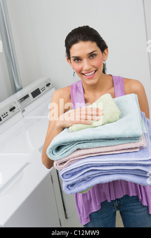 USA, New Jersey, Jersey City, woman holding stack of fresh towels Stock Photo