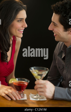 Young couple having drinks and flirting, studio shot Stock Photo