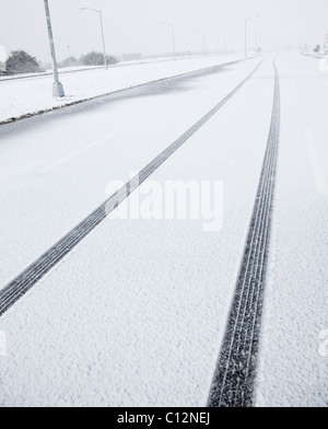 USA, New York State, Rockaway Beach, tire track in snow on road Stock Photo