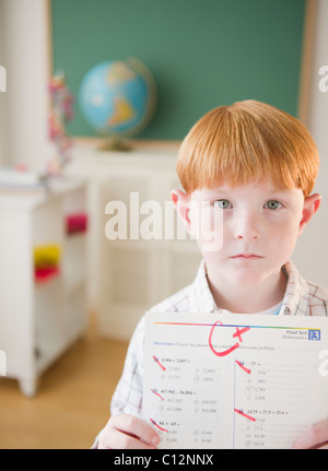 USA, New Jersey, Jersey City, Portrait of boy (8-9) holding test results in classroom Stock Photo