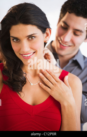 USA, New Jersey, Jersey City, Young couple, man fastening woman's necklace Stock Photo