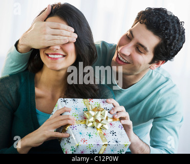 USA, New Jersey, Jersey City, Young man giving his girlfriend present while covering her eyes Stock Photo