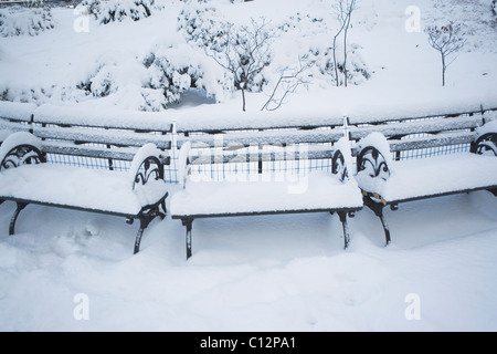 USA, New York City, Manhattan, Benches in Central Park covered with snow Stock Photo