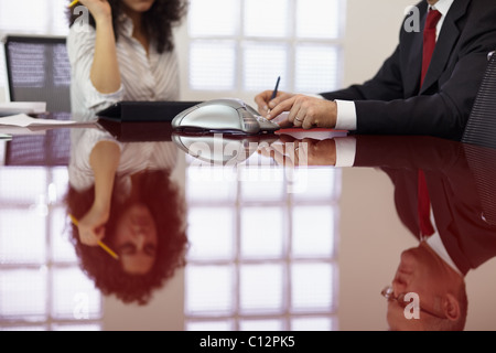caucasian businessman and businesswoman in office meeting room, dialing on phone. Horizontal shape, side view Stock Photo