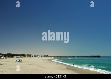 Scenic image of beach and waves breaking, view of Swakopmund pier and beachfront, Namibia Stock Photo