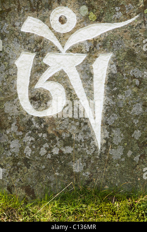 The first symbol of the Buddhist mantra, Om Mani Padme Hum, written on a stone, Holy Island, Isle of Arran, Scotland, UK. Stock Photo