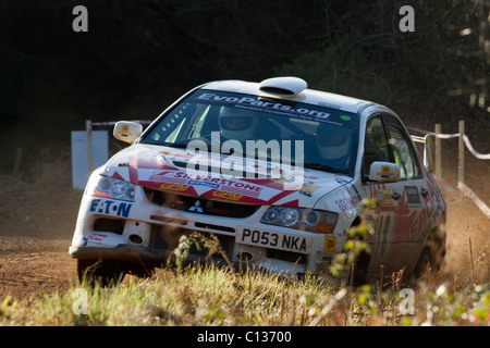 A rally car almost going off the road as it exits a bend. Stock Photo