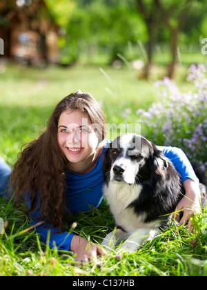USA, Colorado, Portrait of young woman embracing dog on grass Stock Photo