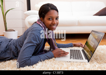 Smiling black woman using her laptop Stock Photo