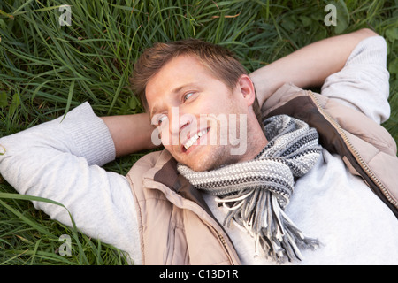 Young man lying alone on grass Stock Photo
