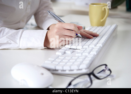 Writing on a white computer keyboard. Womem hands. In the office. Stock Photo