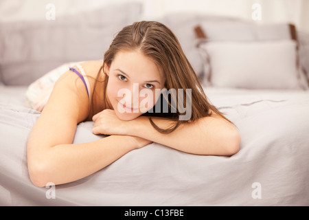 USA, Utah, Lehi, Portrait of young woman relaxing on bed Stock Photo