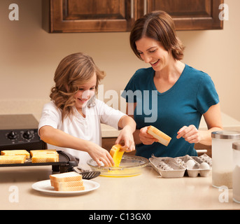 USA, Utah, Lehi, Mother preparing breakfast with daughter (10-11) in kitchen Stock Photo