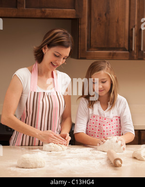 USA, Utah, Lehi, Mother and daughter (10-11) kneading dough in kitchen Stock Photo