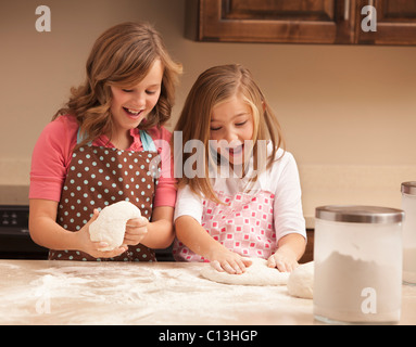 USA, Utah, Lehi, Two girls (10-11) kneading dough in kitchen Stock Photo