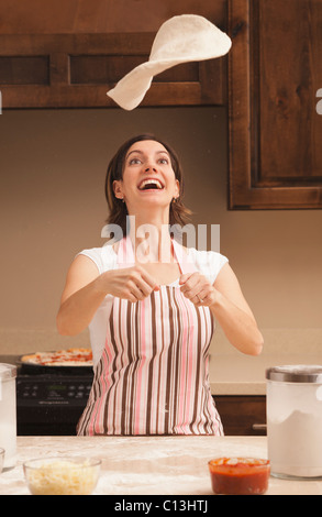 USA, Utah, Lehi, Woman tossing dough in kitchen Stock Photo