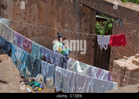 Woman and washing line in urban back yard. Antanananarivo. Madagascar Stock Photo