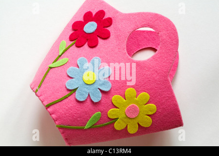 Pretty pink felt bag with brightly coloured daisies on set on white background - ready for Easter Stock Photo