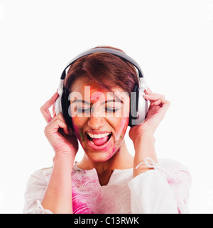 Woman listening to headphones on Holi Stock Photo