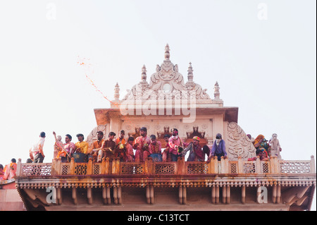People celebrating Holi festival in a temple, Barsana, Uttar Pradesh, India Stock Photo