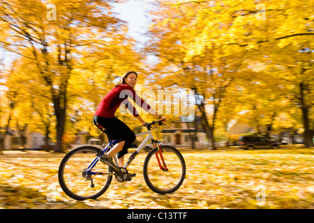 USA, Montana, Kalispell, Young woman cycling in park Stock Photo