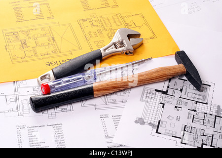 Tools on Blueprints including hammer, screw driver and monkey wrench. House plans printed on white and yellow paper Stock Photo