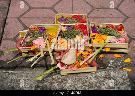 Religious offerings on the pavement in Ubud, Bali, Indonesia Stock Photo