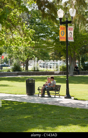 Couple sitting on park bench. City Park in downtown Paso Robles, California. Stock Photo