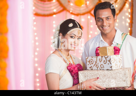 Portrait of a newlywed couple holding presents Stock Photo