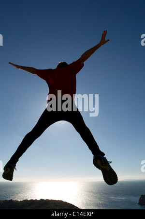 Man leaping through the air by the sea Stock Photo