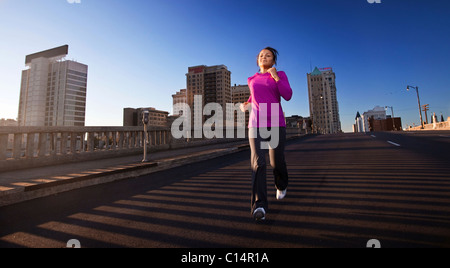 A teenage girl runs downhill on a street in downtown Birmingham, Alabama. Stock Photo