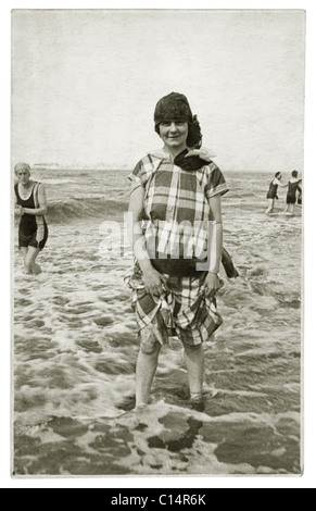 Original 1920's era postcard of young woman in leisure wear paddling in sea -early 1920's pastimes, U.K. Retro beach photo. Stock Photo
