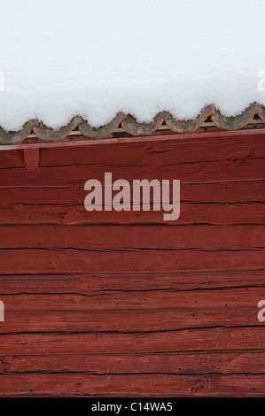 Red house with roof covered in snow, Sweden Stock Photo