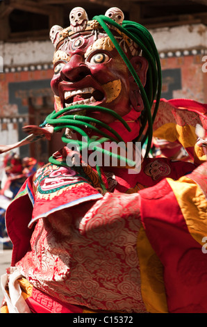 Bhutanese dancer in vivid demon-like costume dances in a religious ...