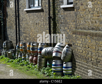 Aluminium beer barrels stacked against a brick wall.  Photograph by Gordon Scammell Stock Photo