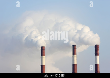 Three smoking chimneys other blue sky Stock Photo