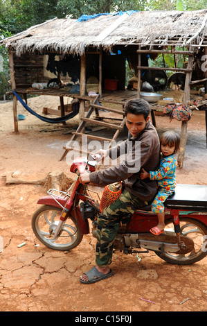 Happy dad carries serious podgy cute son. Stock Photo