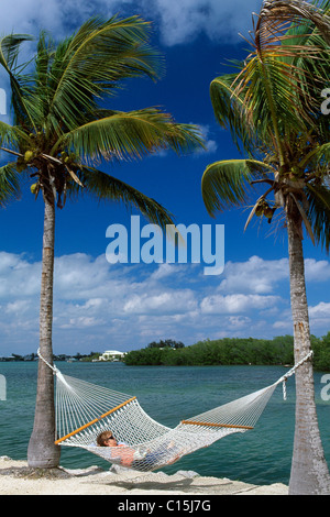 Woman lying on a hammock at the Garden Cove Resort, Key Largo, Florida Keys, Florida, USA Stock Photo