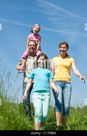 Family going over meadow Stock Photo