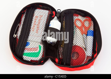Hiker's small first aid kit open with various dressings in a convenient zipped bag isolated on a white background. England UK Stock Photo