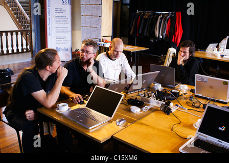 Open source software developers working together at a 'hackathon' meetup. Stock Photo
