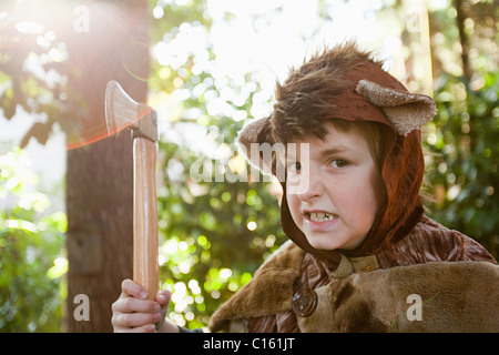 Boy dressed up as bear with toy axe Stock Photo