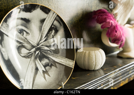 Fornasetti plate on marble mantelpiece with dead sea urchin Stock Photo