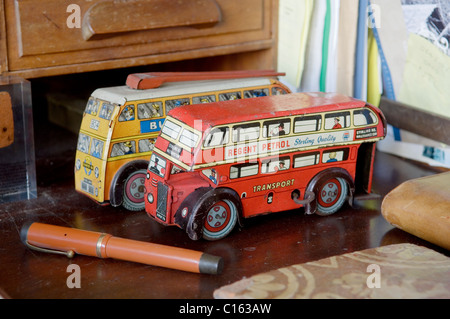 Pair of vintage London bus toys on desk top with pen. Stock Photo