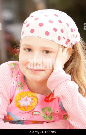 Girl, 8 years old, wearing a headscarf and smiling while looking into the camera Stock Photo